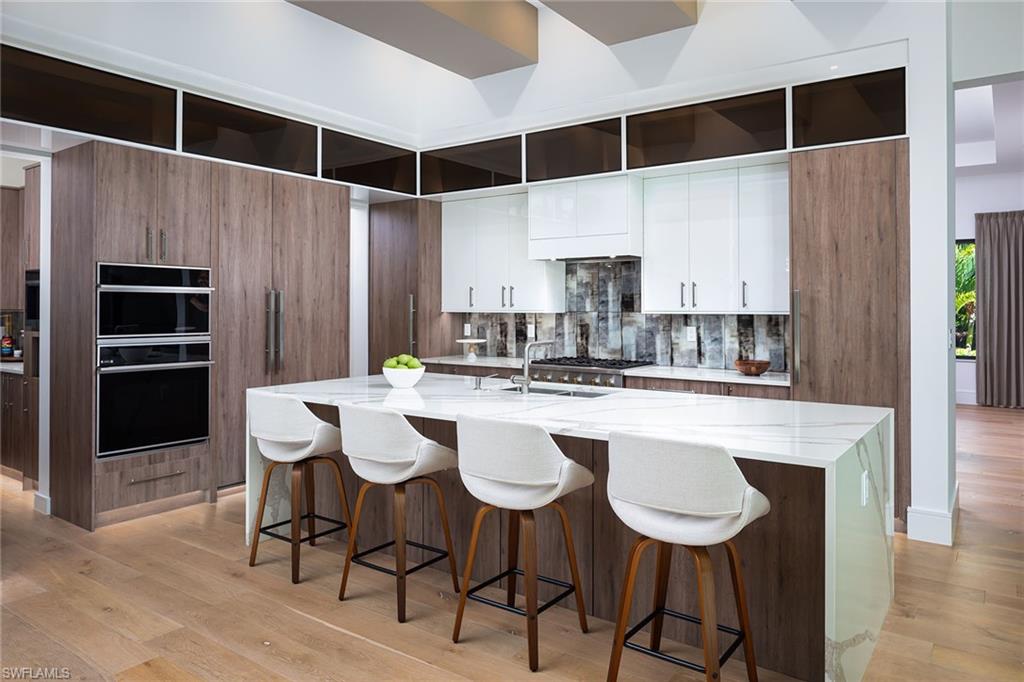 494 Gordonia Road Naples, FL 34108 - Photo 7 of 42 a kitchen with a sink and chairs
