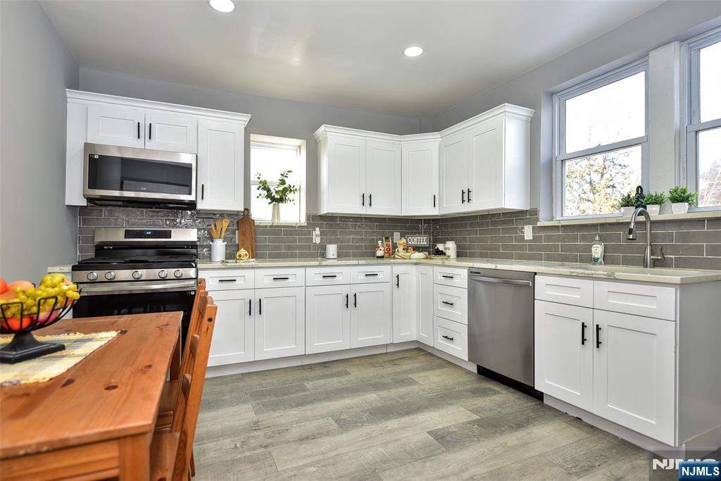 228 Ridgefield Avenue Bogota, NJ 07603 - Photo 12 of 29 a kitchen with stainless steel appliances white cabinets a sink and a stove
