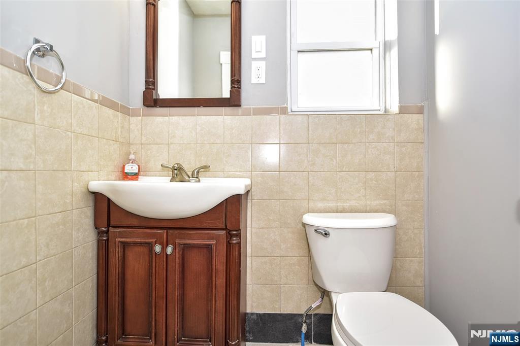 228 Ridgefield Avenue Bogota, NJ 07603 - Photo 14 of 29 a bathroom with a sink a toilet and mirror
