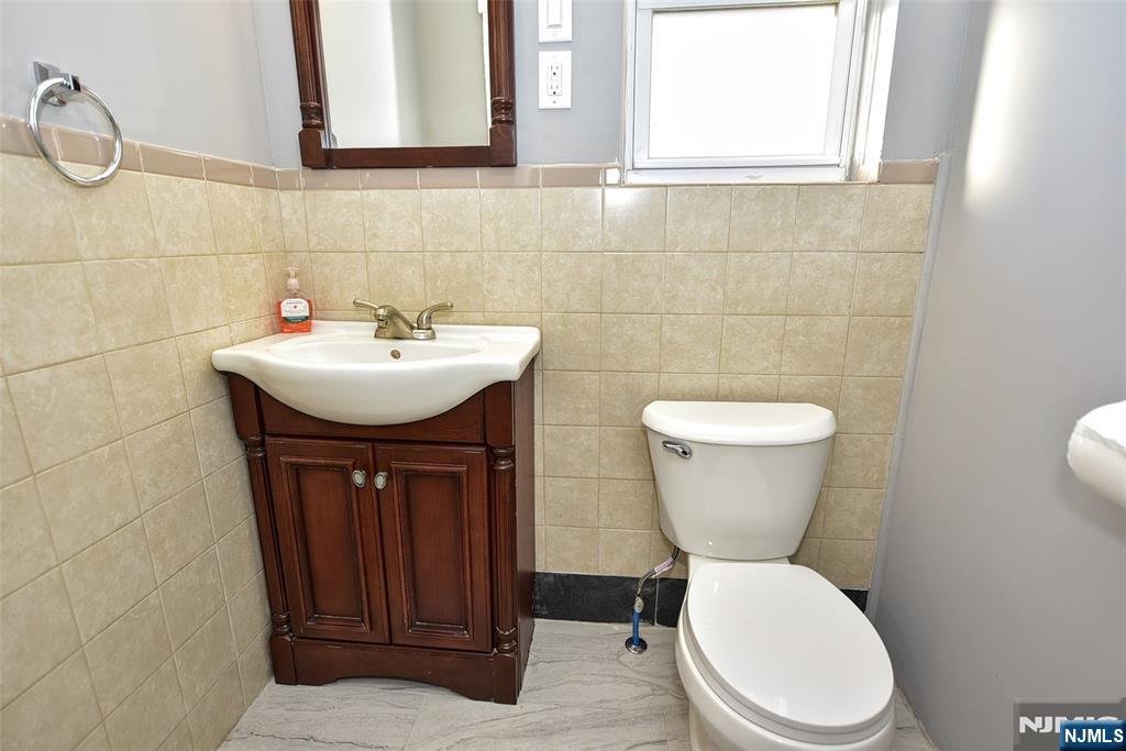 228 Ridgefield Avenue Bogota, NJ 07603 - Photo 15 of 29 a bathroom with a toilet a sink and a mirror