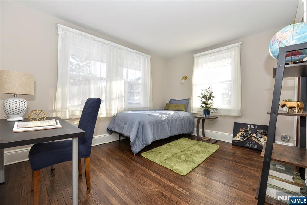 228 Ridgefield Avenue Bogota, NJ 07603 - Photo 19 of 29 a bedroom with a bed a table and a bookshelf
