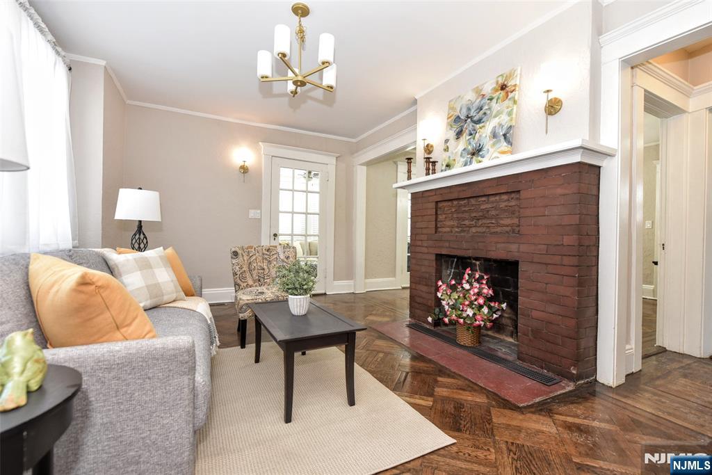 228 Ridgefield Avenue Bogota, NJ 07603 - Photo 3 of 29 a living room with furniture a chandelier and a fireplace