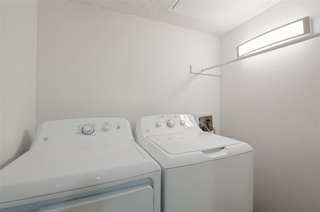 5300 Keller Springs Road, Unit 2042 Dallas, TX 75248 - Photo 24 of 28 Dedicated laundry area featuring white appliances, a wall-mounted drying rod, overhead fluorescent lighting, and a textured ceiling