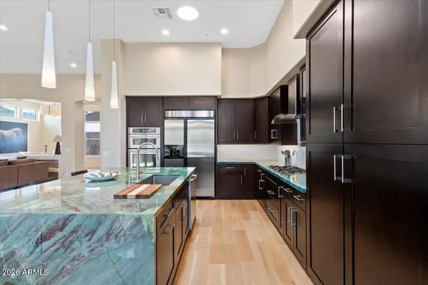 a kitchen with stainless steel appliances granite countertop a sink a stove and a refrigerator