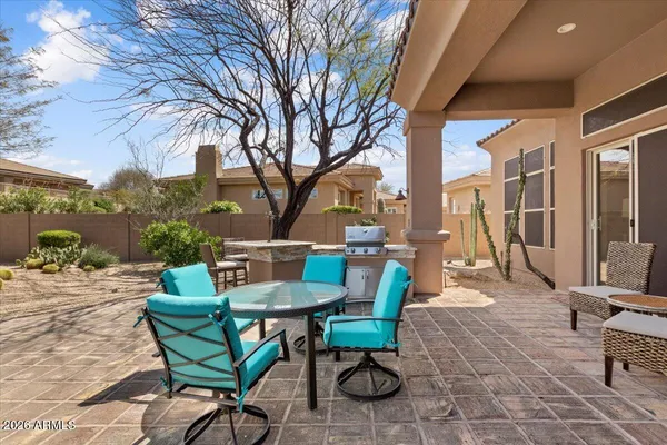 a view of a patio with table and chairs and floor to ceiling window