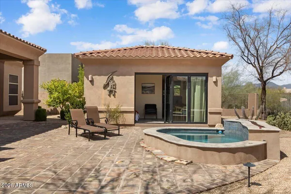 a view of a house with backyard sitting area and swimming pool