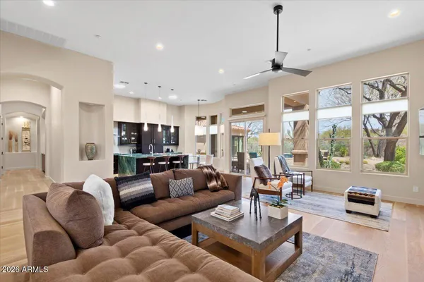 a living room with furniture kitchen view and large windows