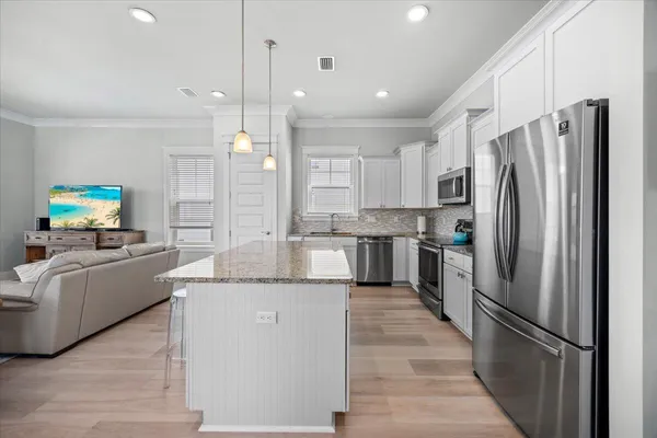 a kitchen with granite countertop a sink a counter top space and living room view