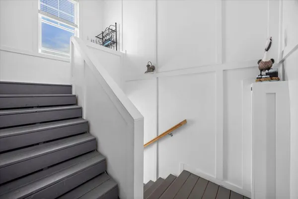 a view of a hallway with wooden floor and stairs