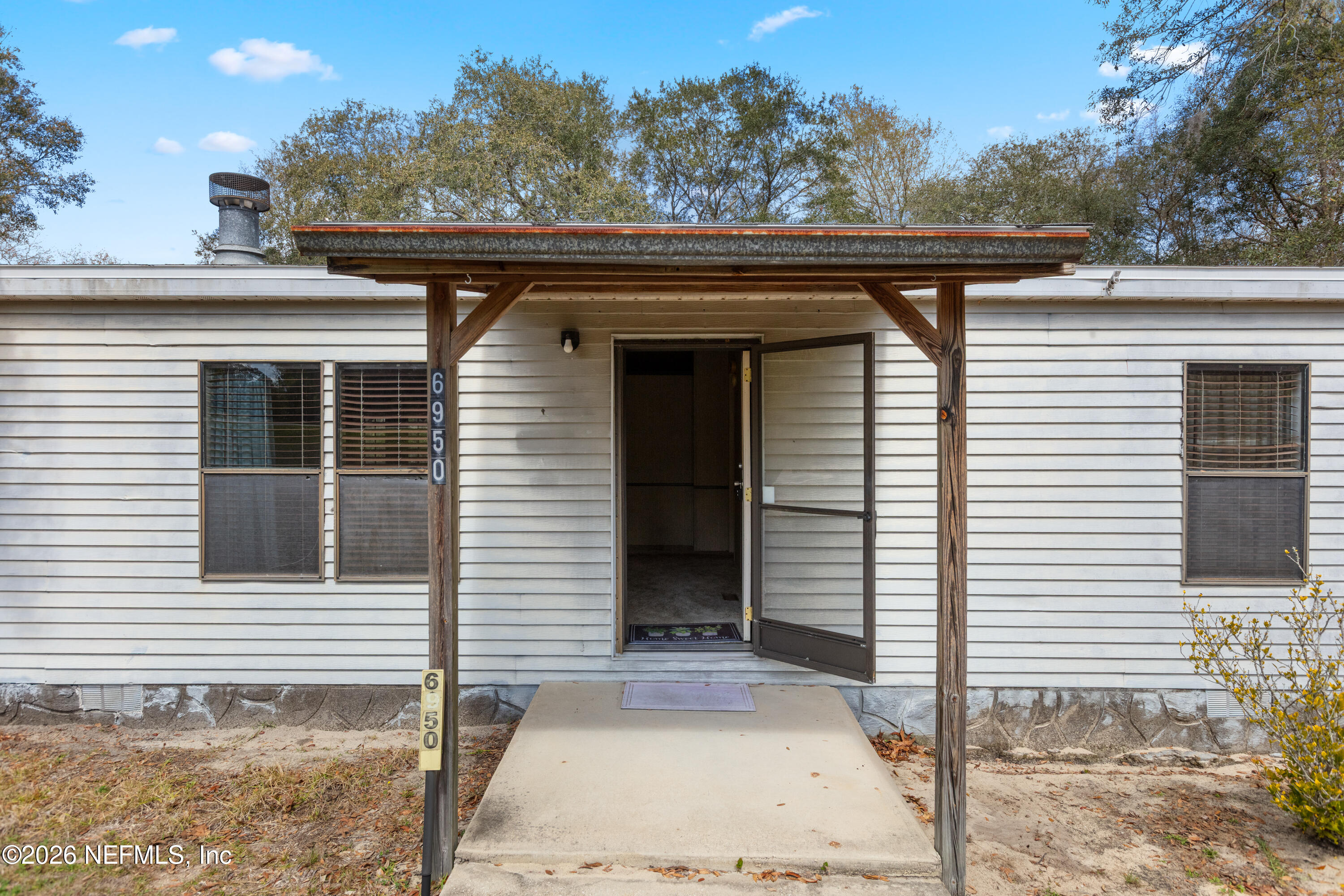 6950 Deer Springs Road Keystone Heights, FL 32656 - Photo 3 of 46 a side view of a house with a porch