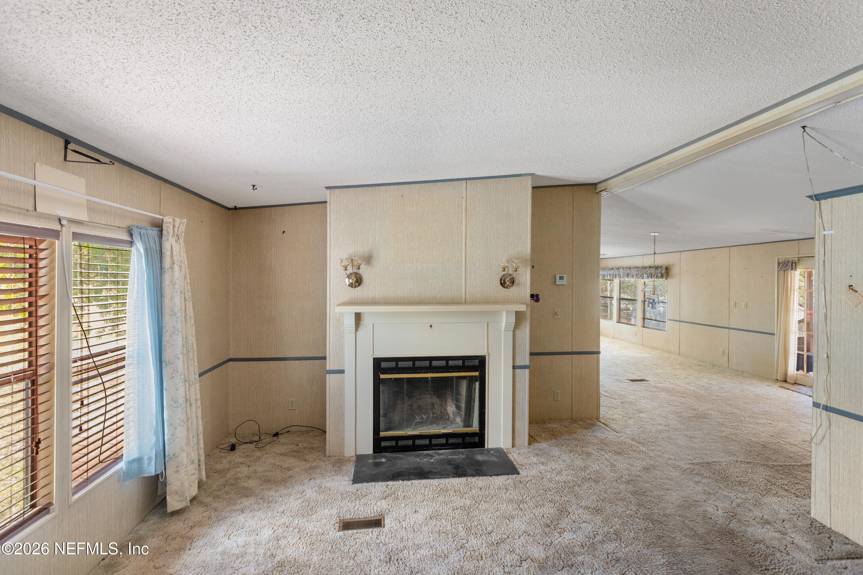 6950 Deer Springs Road Keystone Heights, FL 32656 - Photo 5 of 46 an empty room with fireplace and windows