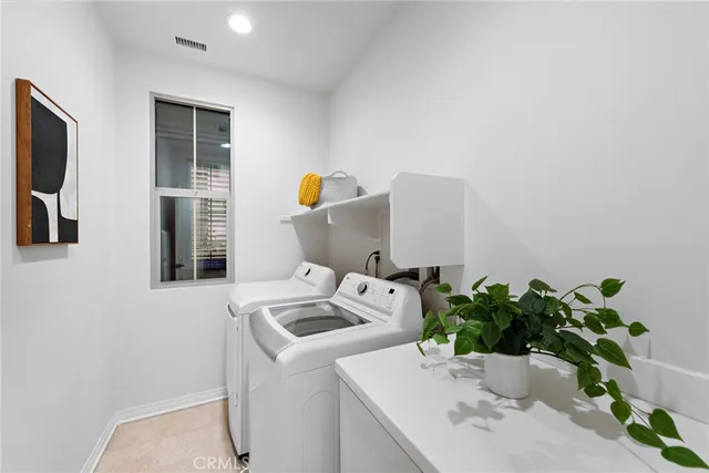 a bedroom with a large bed a chandelier and dresser