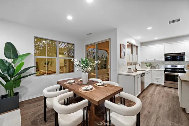 a open dining room with furniture a window and wooden floor