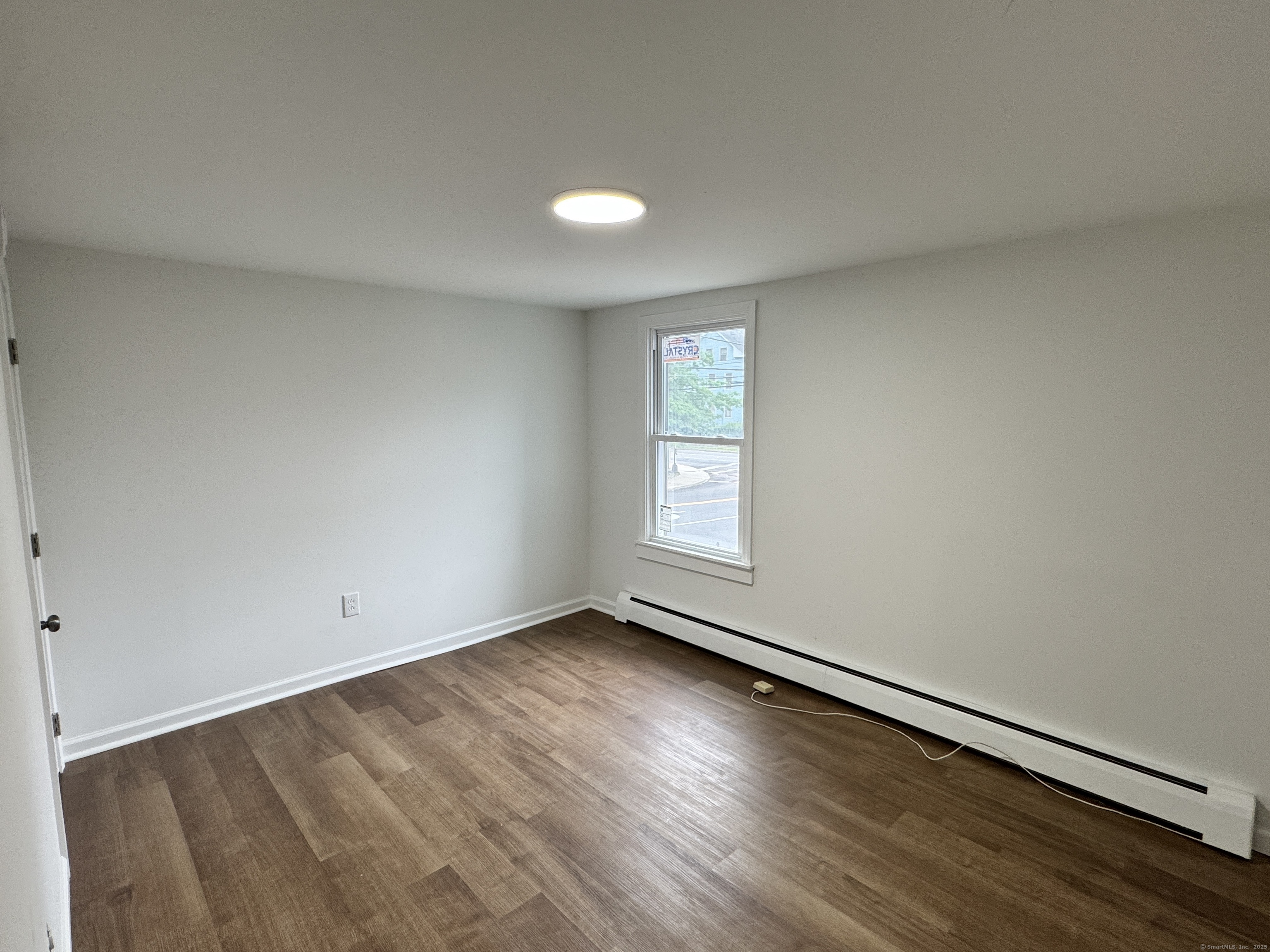 81 Springdale Avenue, Unit 2 Meriden, CT 06451 - Photo 13 of 19 an empty room with wooden floor and windows
