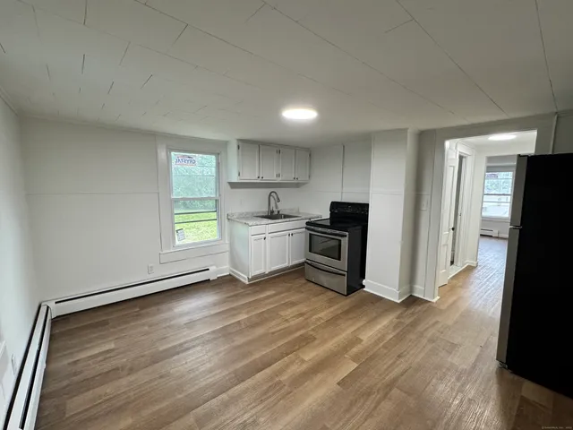 a kitchen with stainless steel appliances a refrigerator and wooden floor