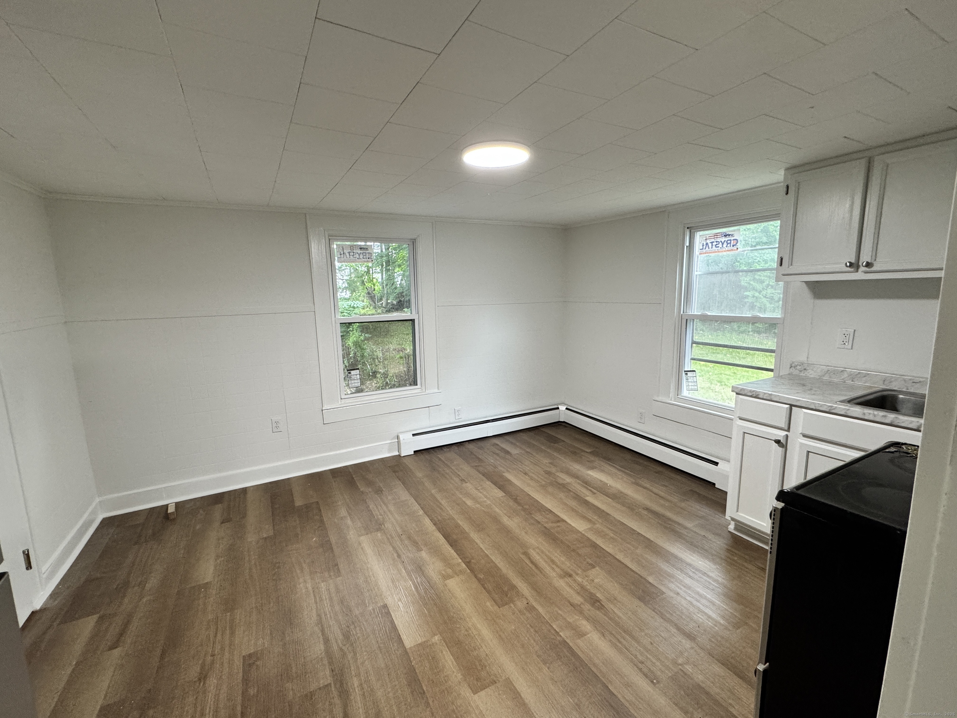 81 Springdale Avenue, Unit 2 Meriden, CT 06451 - Photo 3 of 19 an empty room with wooden floor and windows