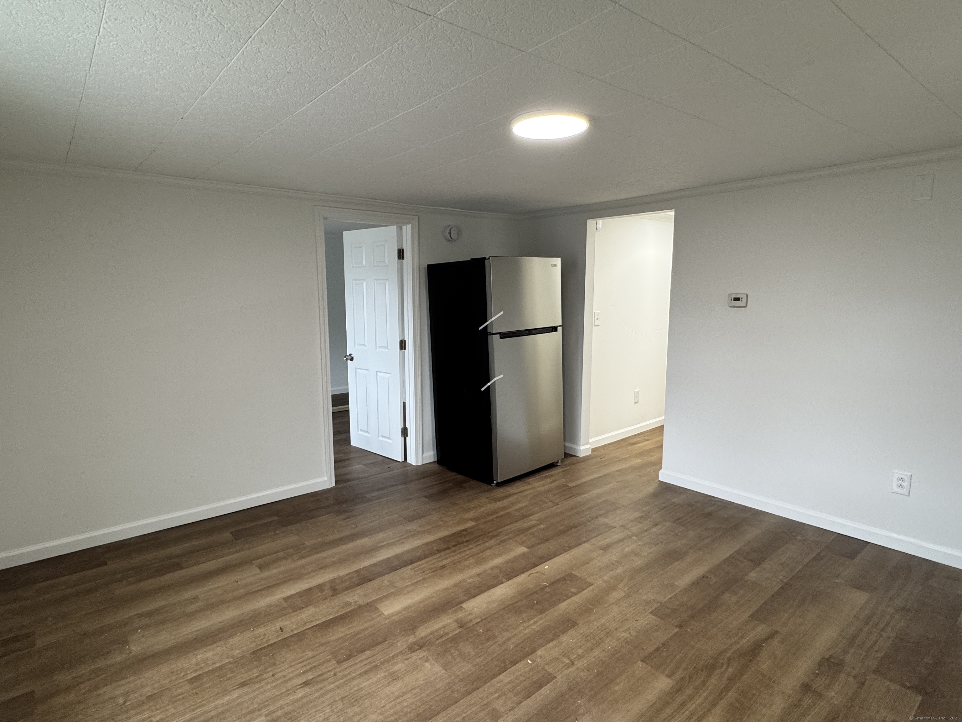 81 Springdale Avenue, Unit 2 Meriden, CT 06451 - Photo 5 of 19 a view of an empty room with wooden floor and a kitchen