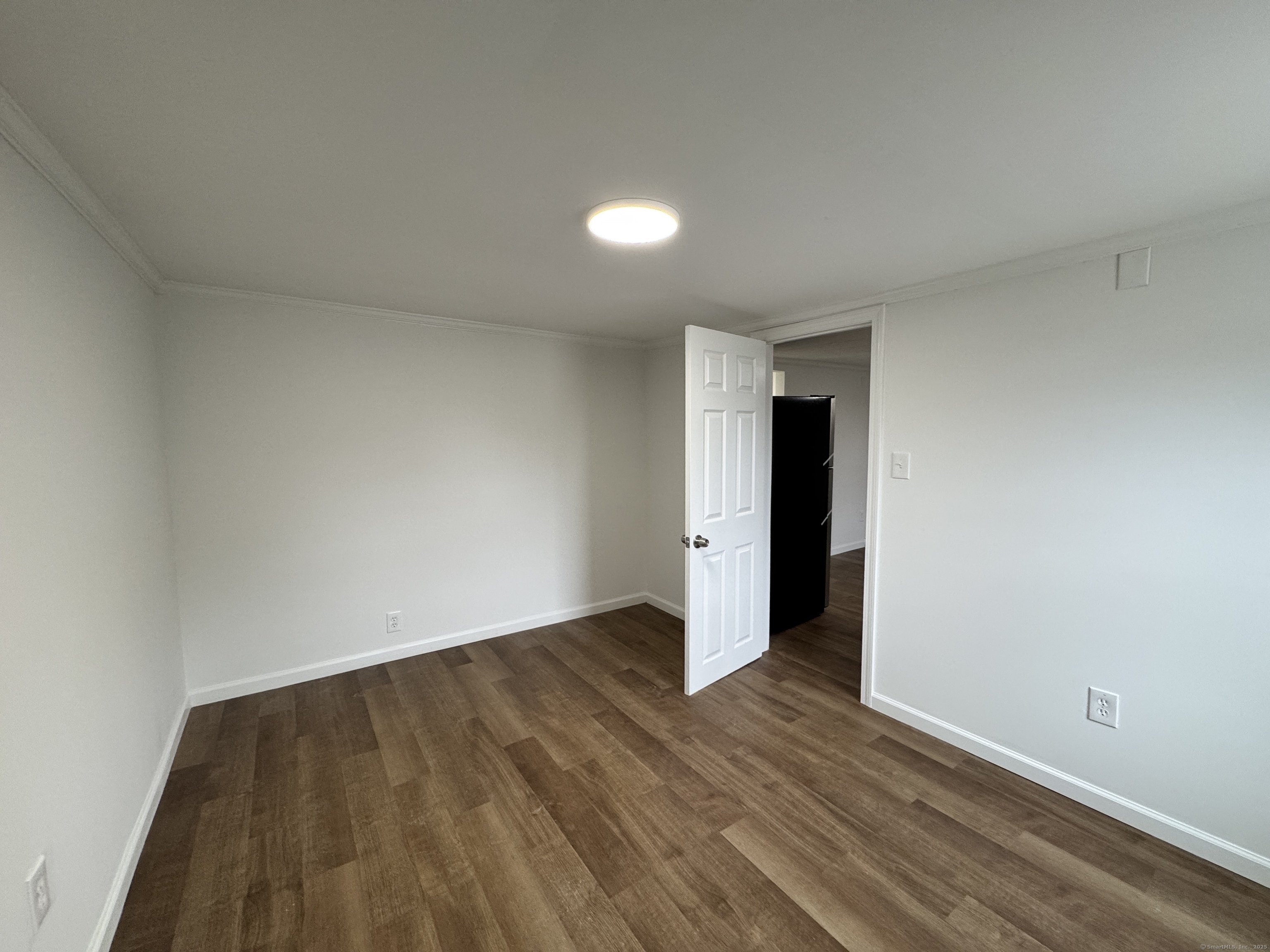 81 Springdale Avenue, Unit 2 Meriden, CT 06451 - Photo 7 of 19 a view of an empty room with wooden floor and a window