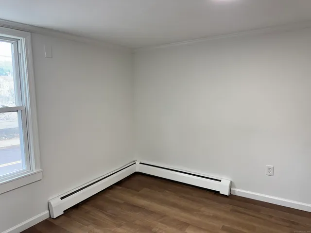 a view of a room with wooden floor and window