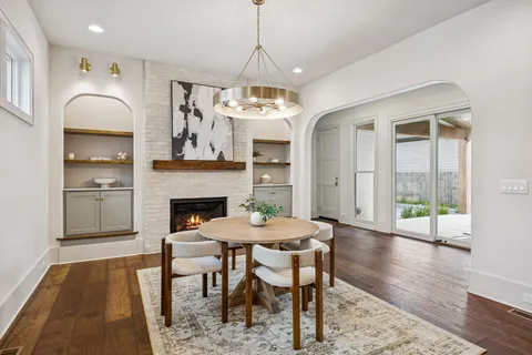 an empty room with wooden floor chandelier and windows