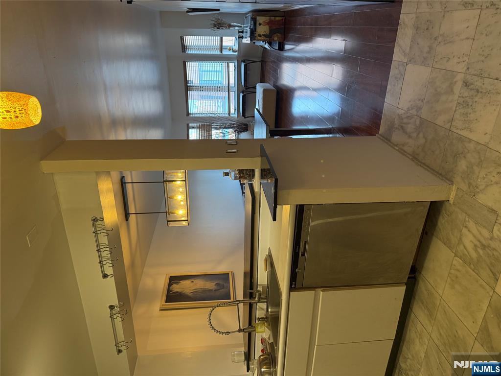 402 Williams Court, Unit U402 Edgewater, NJ 07020 - Photo 4 of 7 a kitchen with stainless steel appliances granite countertop a stove a sink and a microwave