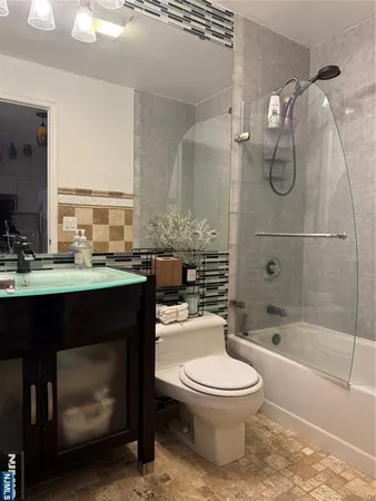 a bathroom with a granite countertop toilet a sink and a bathtub