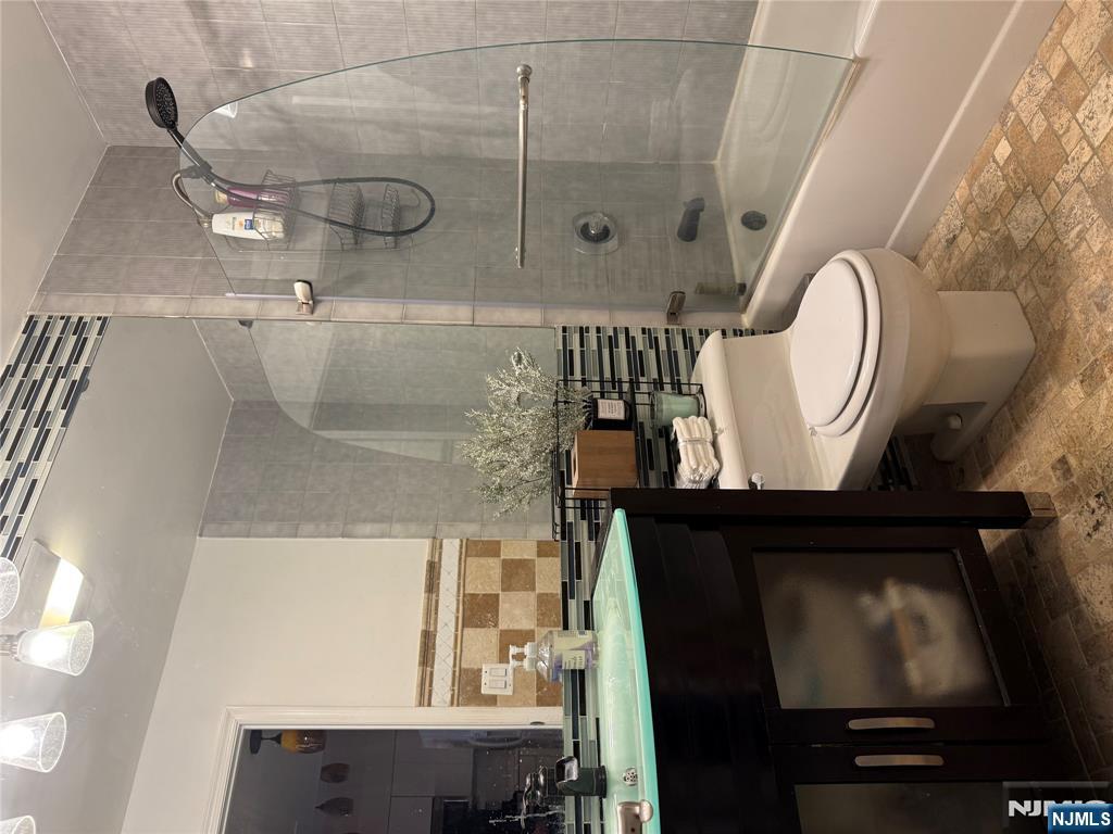 402 Williams Court, Unit U402 Edgewater, NJ 07020 - Photo 5 of 7 a bathroom with a granite countertop toilet a sink and a bathtub