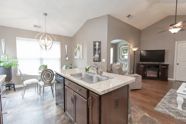 a view of kitchen island with granite countertop couches a dining table and chairs