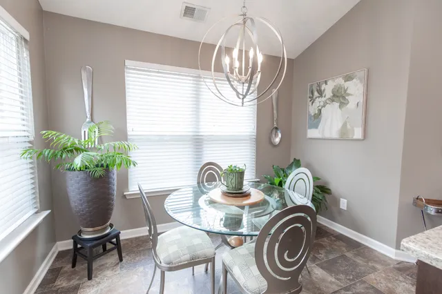 a dining room with furniture a potted plant and a window