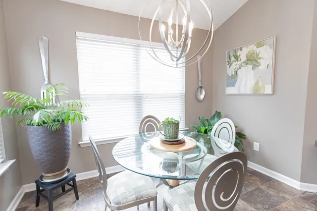 a dining room with furniture potted plants and wooden floor