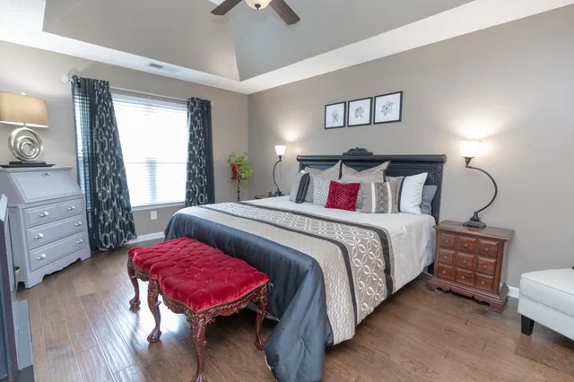 a bedroom with a bed a dresser and a window