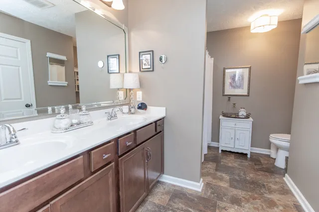 a bathroom with a toilet a sink a mirror and vanity