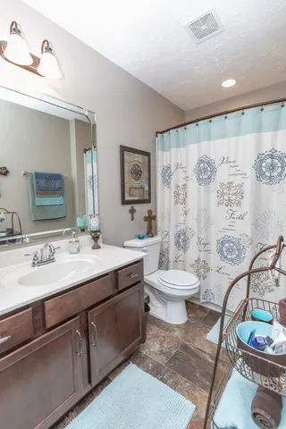 a bathroom with a toilet sink and mirror