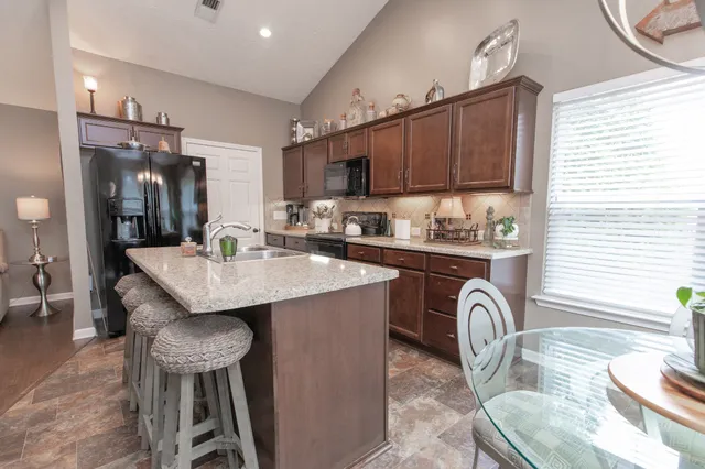 a kitchen with a table chairs sink and cabinets