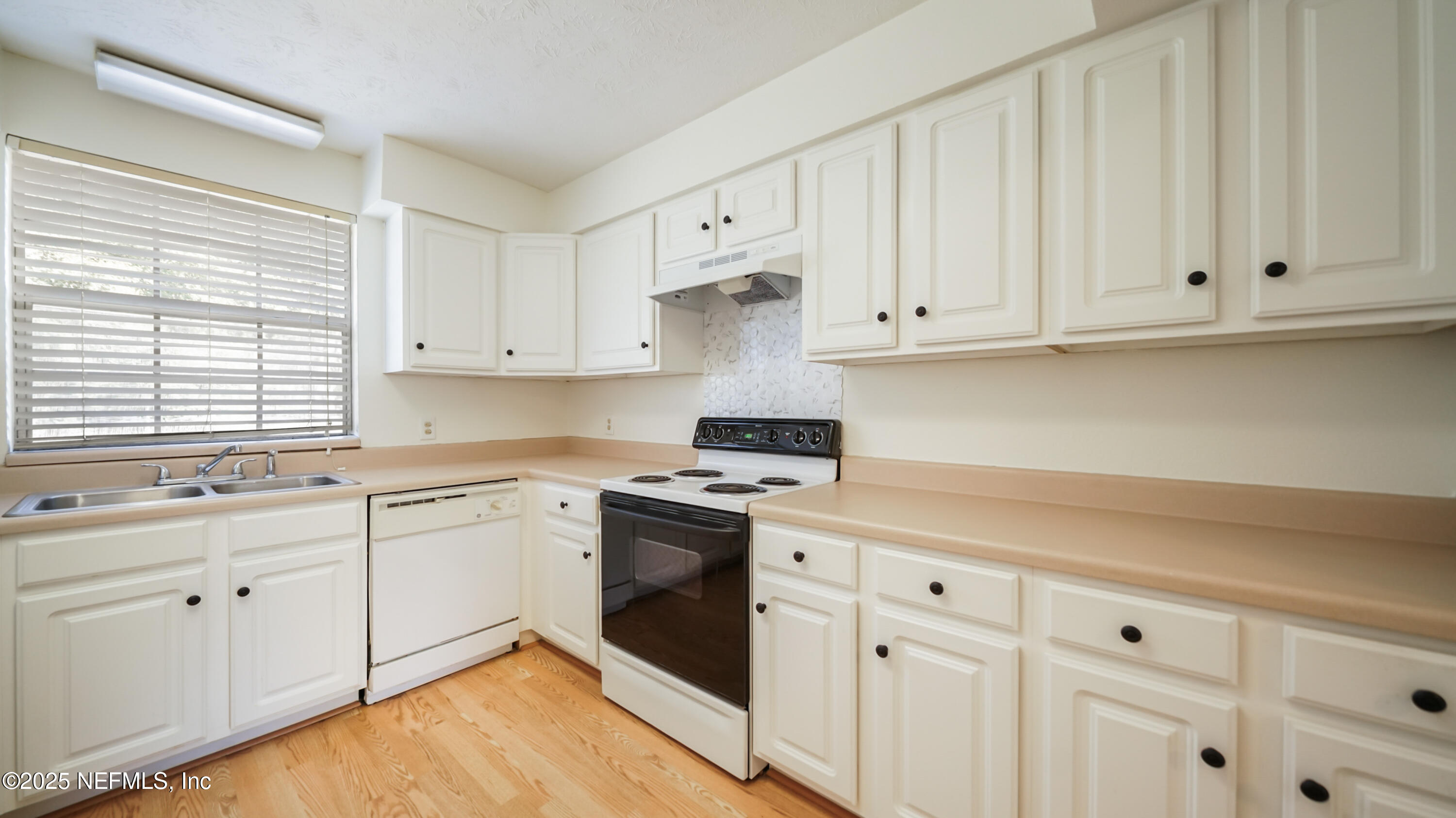 4915 Baymeadows Road, Unit 7H Jacksonville, FL 32217 - Photo 11 of 33 a kitchen with white cabinets and white appliances