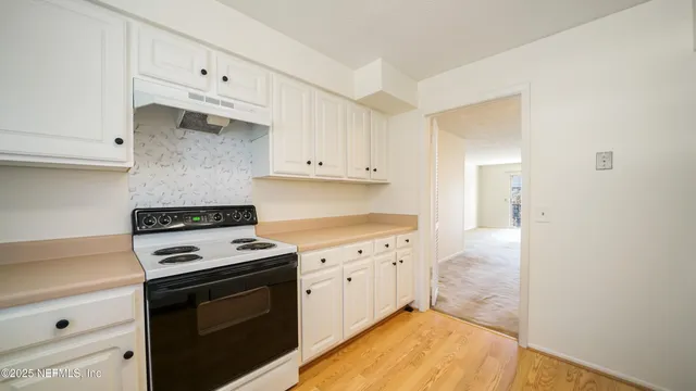 a kitchen with granite countertop white cabinets and appliances