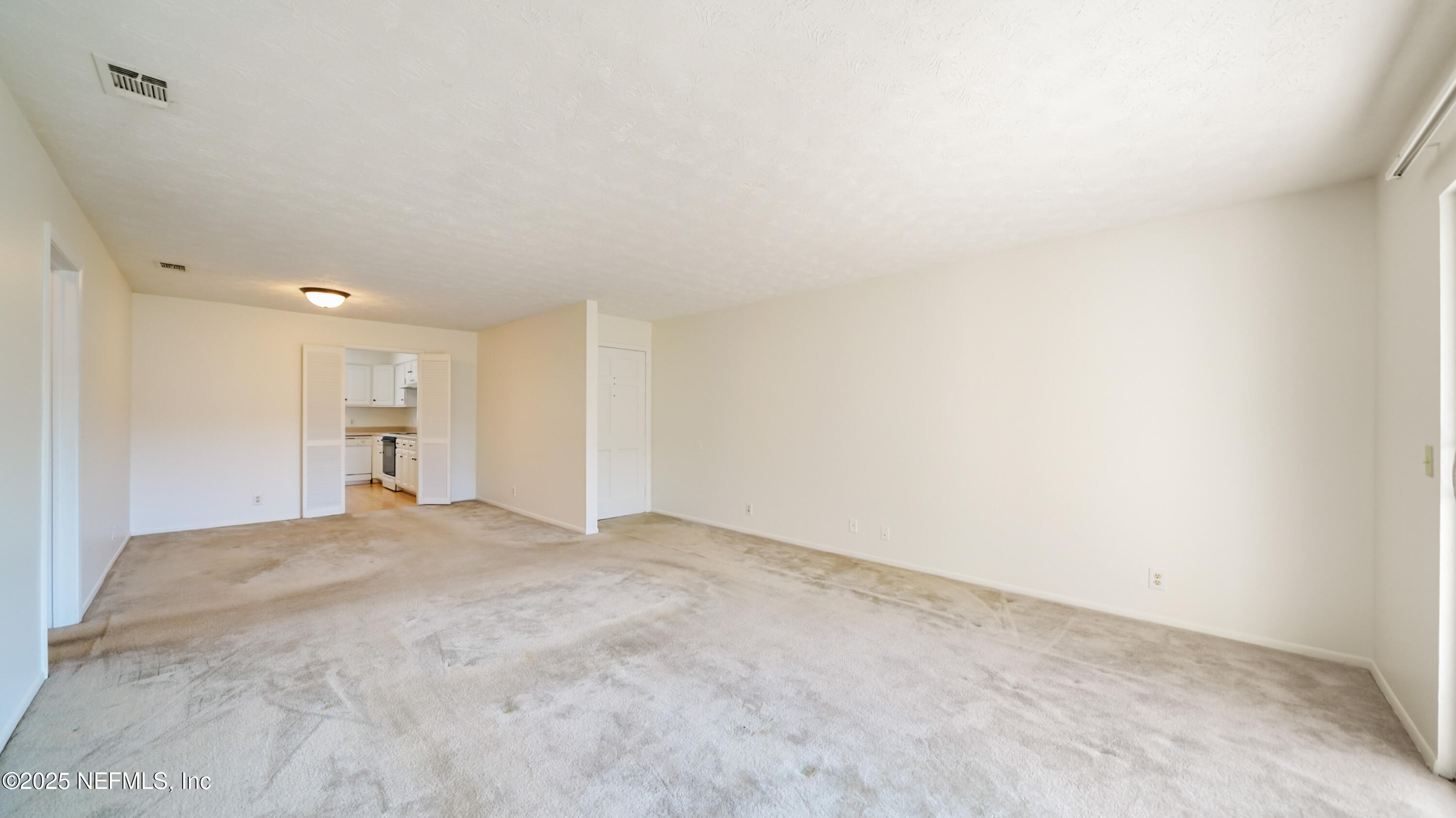 4915 Baymeadows Road, Unit 7H Jacksonville, FL 32217 - Photo 17 of 33 a view of an empty room with a kitchen