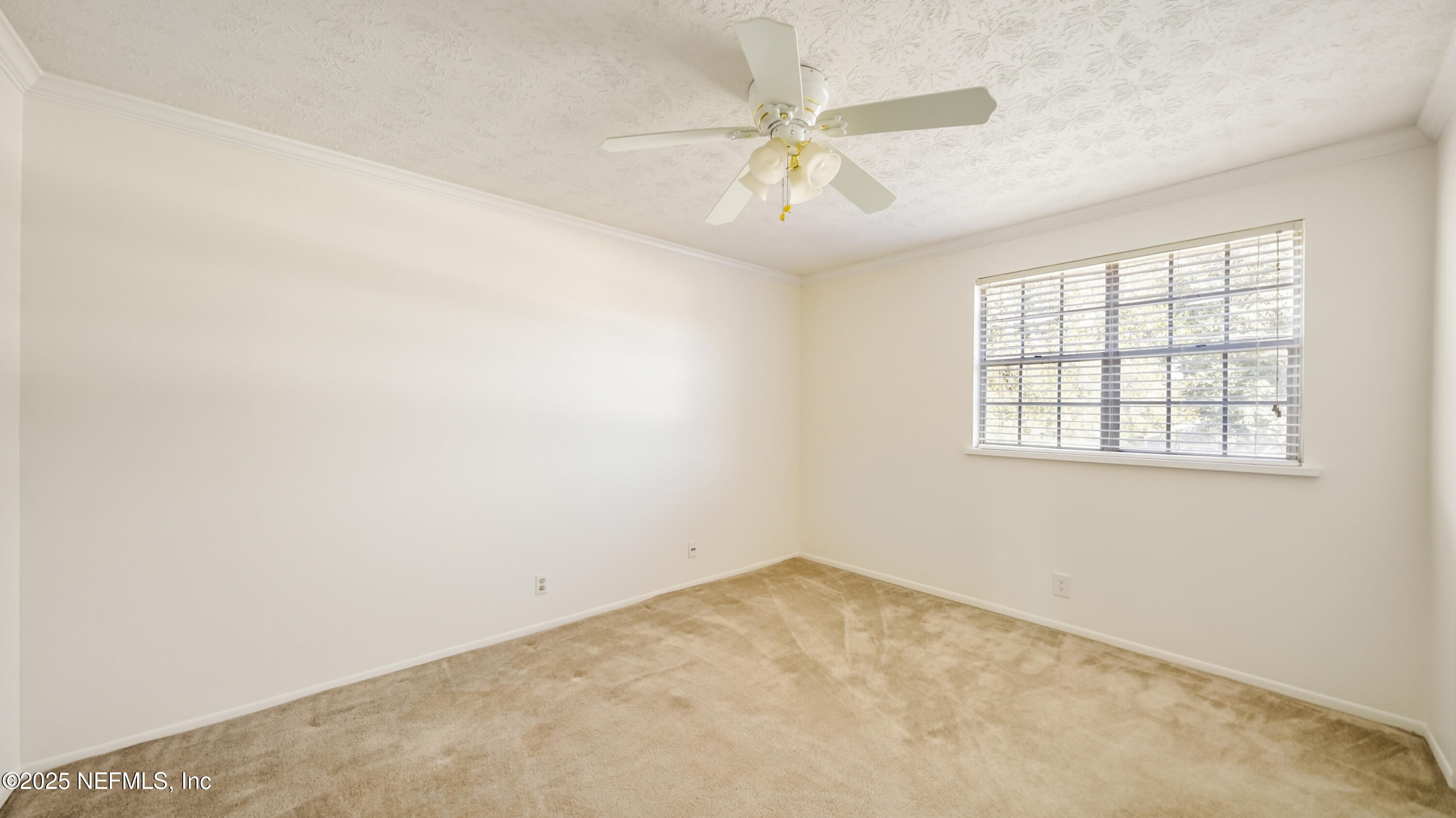 4915 Baymeadows Road, Unit 7H Jacksonville, FL 32217 - Photo 25 of 33 an empty room with a chandelier fan and windows