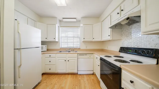 a kitchen with cabinets appliances a sink and a counter space