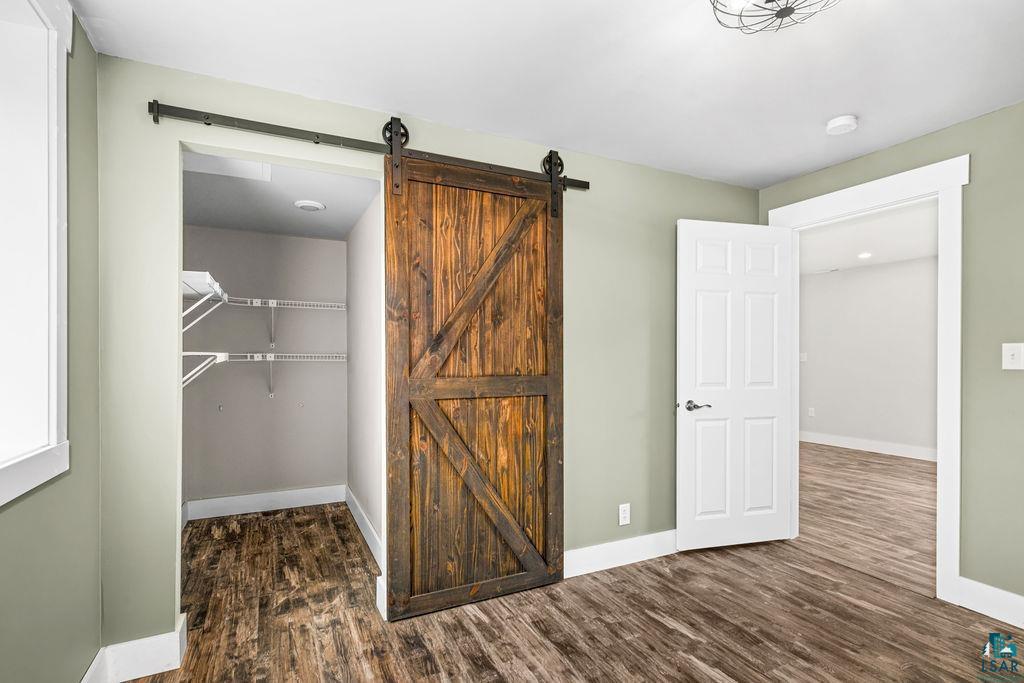 5025 Reid Road Duluth, MN 55803 - Photo 38 of 51 Rustic wood-finish barn door entrance to a closet with wire shelving