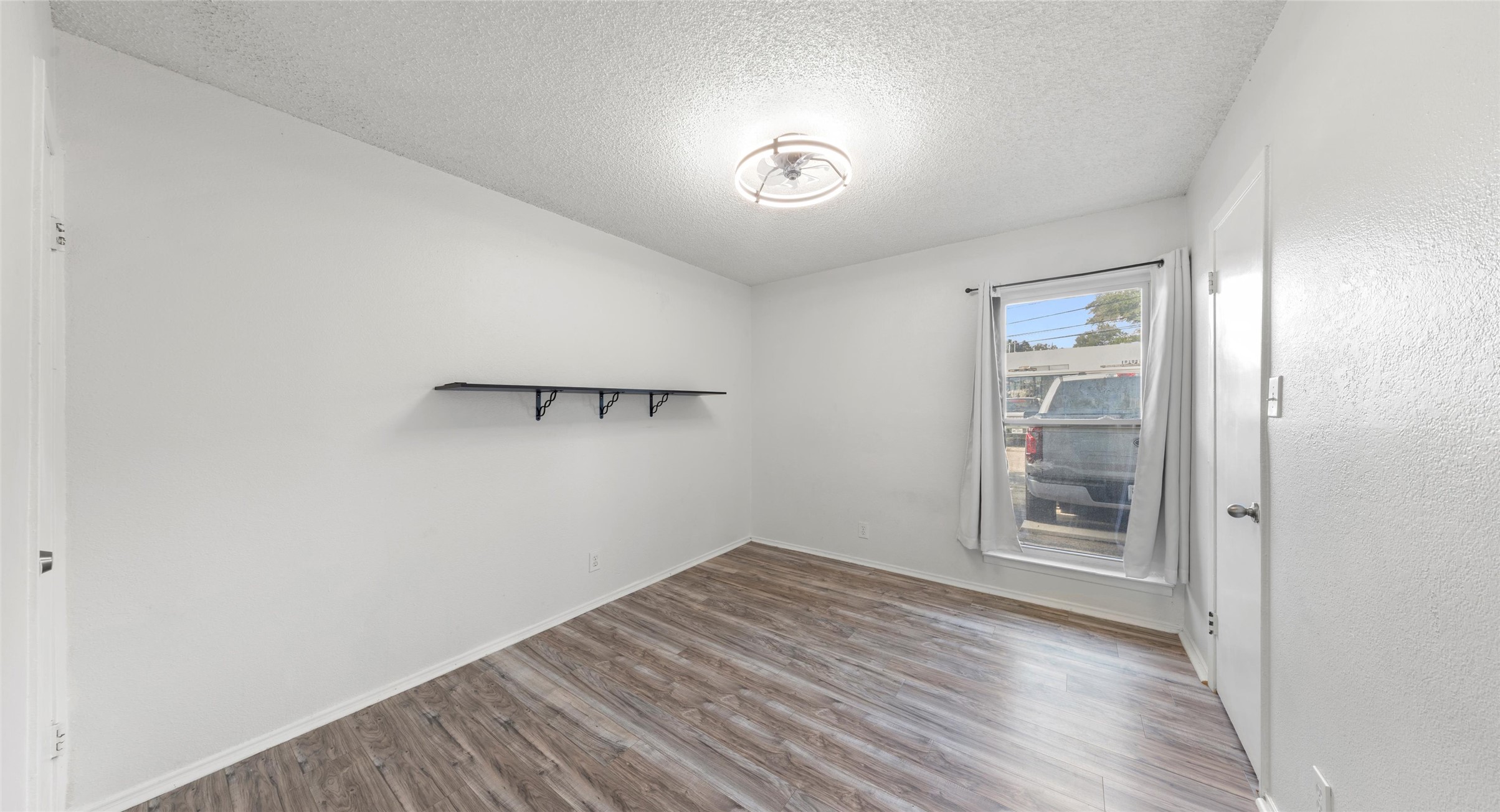 2401 Manor Road, Unit 123 Austin, TX 78722 - Photo 12 of 22 A well-lit room with resilient plank flooring and natural light through the window.