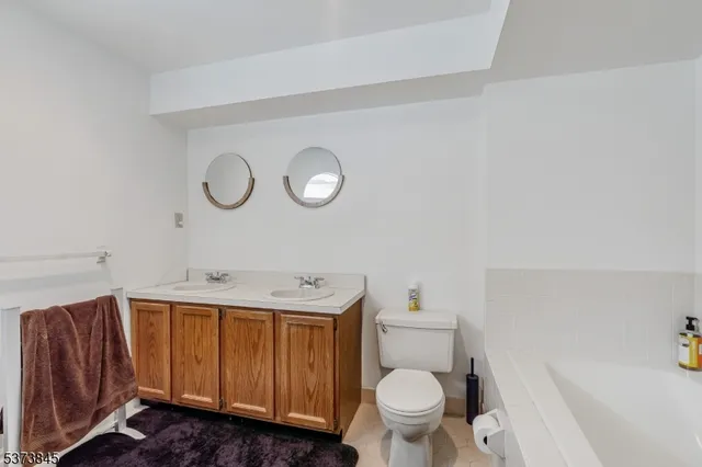 a bathroom with a toilet a sink and a large mirror