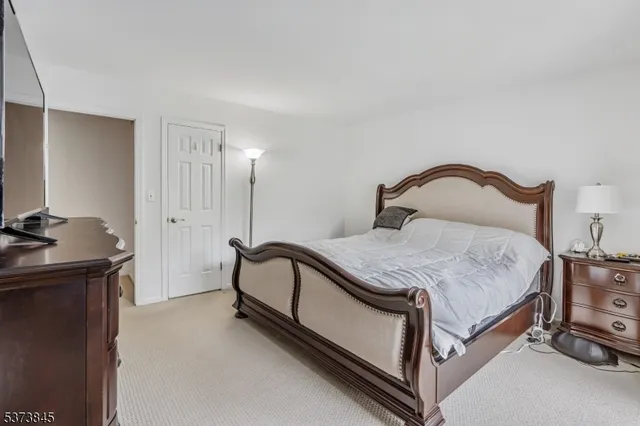 a bedroom with a bed and a potted plant on dresser