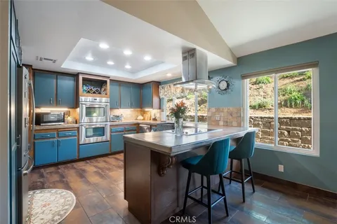 a kitchen with stainless steel appliances granite countertop a stove a refrigerator a sink dishwasher with a dining table and chairs