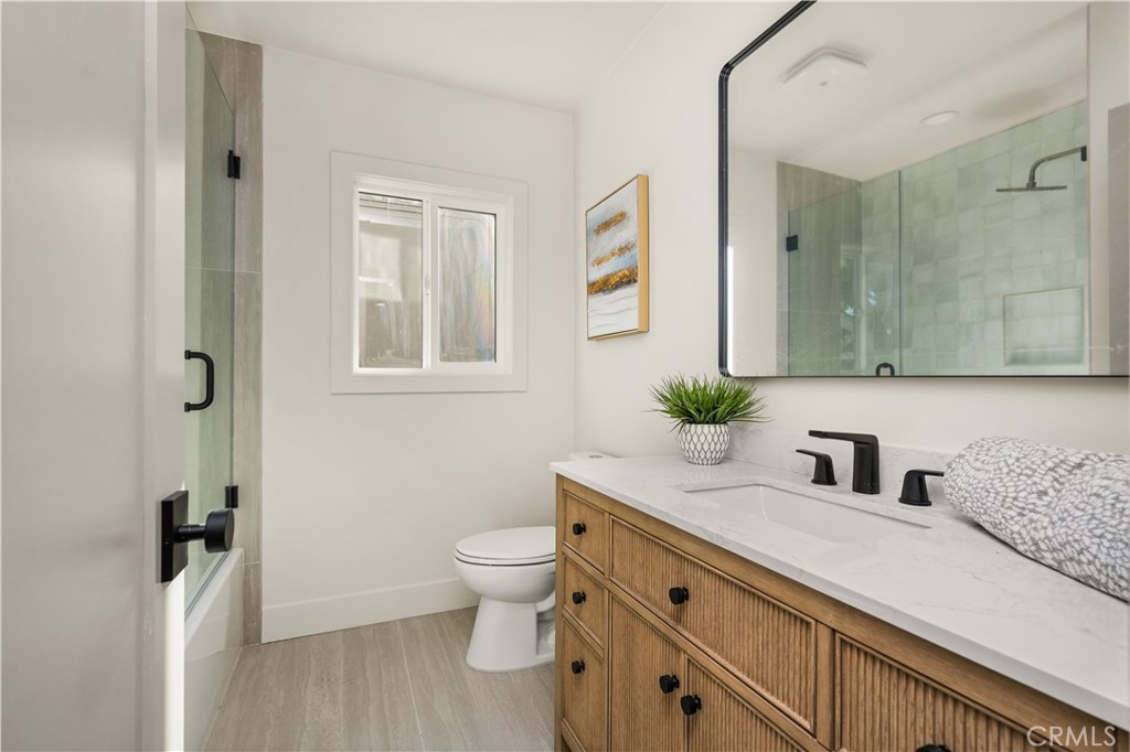 2440 Ostrom Avenue Long Beach, CA 90815 - Photo 39 of 50 a bathroom with a granite countertop toilet sink and mirror