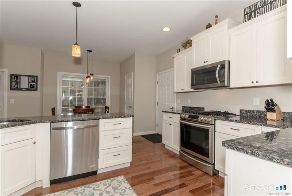 823 Stone Road Windsor, CT 06095 - Photo 12 of 38 a kitchen with stainless steel appliances granite countertop a stove a sink and a microwave