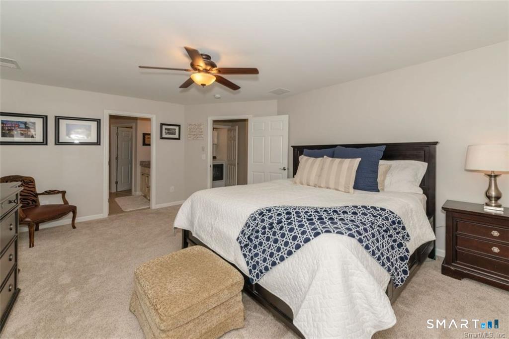 823 Stone Road Windsor, CT 06095 - Photo 25 of 38 a bedroom with a bed and a chandelier