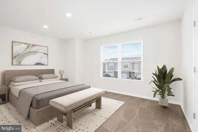 a bedroom with a large bed and a potted plant
