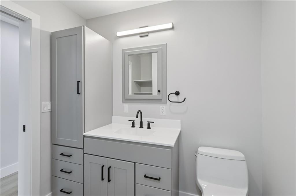 1211 Boyle Street Pittsburgh, PA 15212 - Photo 20 of 38 a bathroom with a toilet a sink a vanity and mirror