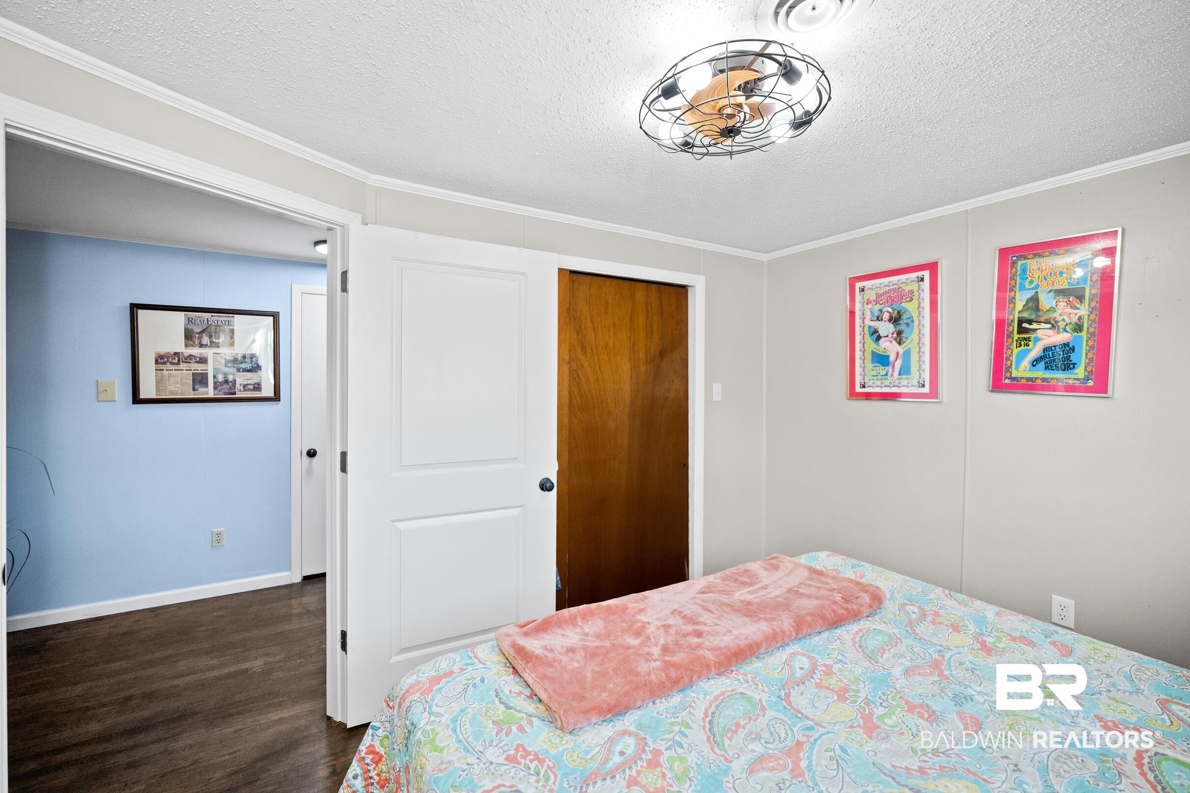 401 West Myrtle Avenue Foley, AL 36535 - Photo 28 of 39 Bedroom with a textured ceiling, crown molding, a closet, and dark wood-style flooring